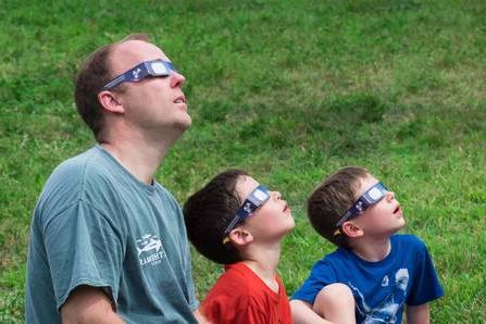 Family looking at solar eclipse